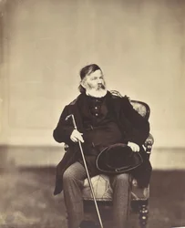 Homme assis avec une canne et un chapeau
