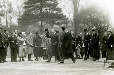 Le roi George V, levant son chapeau à la foule devant son entourage, lors d