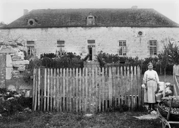 Une paysanne devant sa ferme, dans les environs de Bourmont en Haute-Marne. Photographie fin XIXe siècle. Collection Ducos