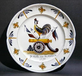 Assiette de Nevers représentant un coq sur un canon