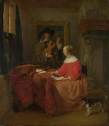 Une femme assise à une table et un homme accordant un violon