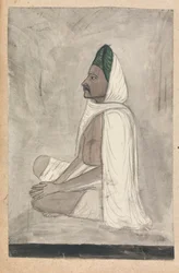 Homme en turban vert assis en tailleur