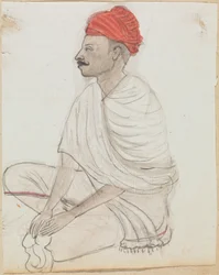 Homme avec un turban rouge assis en tailleur