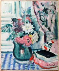 Dahlias mélangés dans un vase vert, avec un livre sur une nappe à carreaux