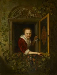 Une fille avec une grappe de raisin à la fenêtre