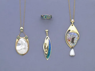 Un groupe de pendentifs en métal jaune et émail de Liberty & Co et une bague conçue par Archibald Knox