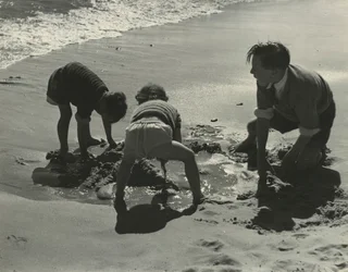 Trois enfants jouant avec du sable à la plage