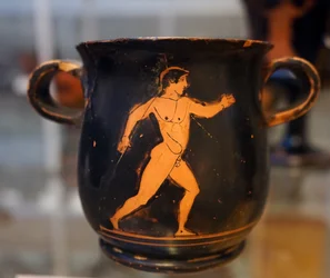 Tasse grecque antique rouge sur noir représentant un athlète