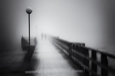 Promenade mystérieuse sur la jetée dans le brouillard