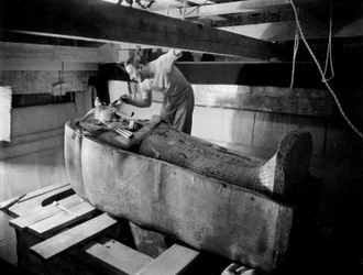 Découverte de la tombe du pharaon Toutânkhamon dans la vallée des Rois (Égypte): dans la chambre funéraire, Howard Carter travaille sur le couvercle du deuxième cercueil, octobre 1925, photo de Harry Burton (p1568)