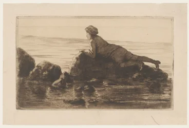 Garçon allongé sur des rochers sur la plage