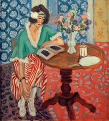 Femme lisant à une table (en robe rayée verte et rouge)
