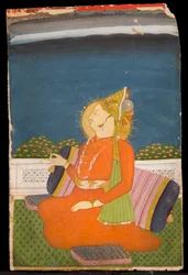 Un dignitaire paré de bijoux, portant un turban à plumes, tenant un bouton de lotus, assis sur une terrasse