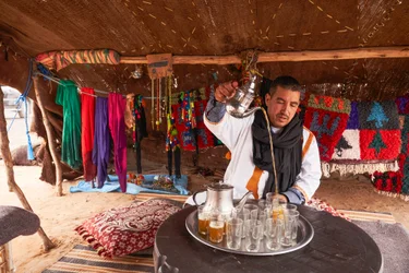 Un local servant du thé à la menthe à Erg Chebbi dans le désert près de Merzouga, Maroc, 2019 (photo)