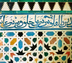 Anneau avec inscription en bleu sur fond blanc reproduisant des phrases du Coran