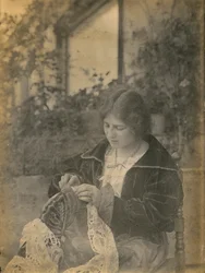 Femme cousant une robe en dentelle, Italie, vers 1910