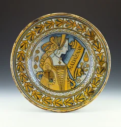 Un plat portrait en céramique bleue et dorée de Deruta représentant une jeune femme de profil et inscrit Madalena B, vers 1525