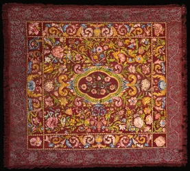 Tapis de table italien brodé de soies colorées avec un médaillon central de roses dans un champ de lys et de grandes fleurs