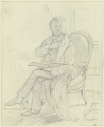 Jeune homme assis dans un fauteuil avec un livre