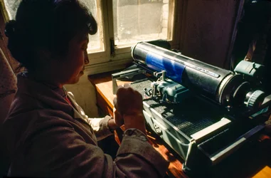 Dans le bureau de la commune, un membre tape sur une machine à écrire chinoise. Commune de Chun Xing, Y