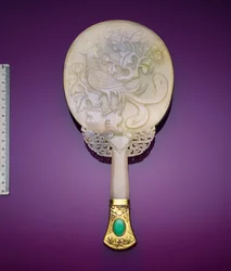 Un miroir en jade blanc et argent doré avec un bas-relief de phénix et de pivoine