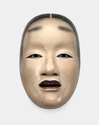 Un masque en bois avec fond gofun, peint avec sumi pour les cheveux, les yeux et les dents et rouge pour les lèvres