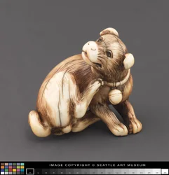 Netsuke modelé en forme de chien se grattant le cou