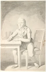 Jeune garçon écrivant assis à une table