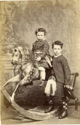 Jeune fille sur un cheval à bascule avec un jeune garçon en kilt debout, années 1860