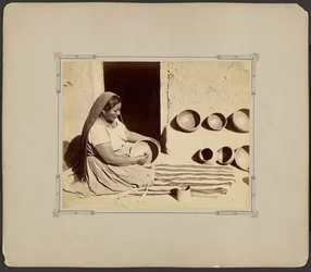 Une femme en train de polir de la poterie
