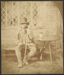 [Homme assis à une table]
