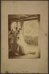 [Femme en robe longue rayée assise à l