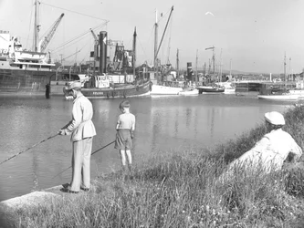 Un homme et un garçon pêchant à Glasson Dock tandis qu