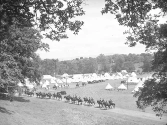 Cavalerie à cheval se déplaçant sur la route vers leur camp avec des tentes à l