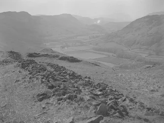 Vue sur une vallée ouverte à Hardknott avec des amas de rochers au premier plan