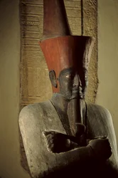 Statue en grès peint du pharaon Nebhepetre Mentouhotep II portant la couronne rouge de Basse-Égypte