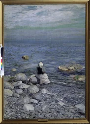 Sur le rivage de la mer Noire. Une femme seule et élégante, assise sur les rochers de la plage, regarde l