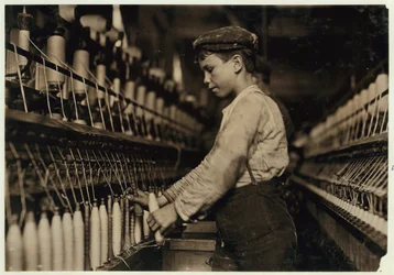 Un doffer remplace des bobines pleines au Globe Cotton Mill, Augusta, Géorgie, 1909