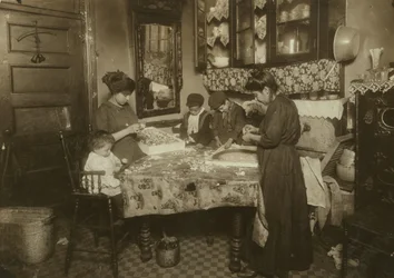 Mme Mette et ses enfants (Josephine 13 ans, Nicholas 6 ans et Johnnie 8 ans gagnant ensemble seulement 40-50 cents par jour) fabriquant des fleurs dans un taudis sale de New York, 1911