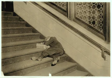 Garçon de journaux endormi avec ses papiers à Jersey City, New Jersey, 1912
