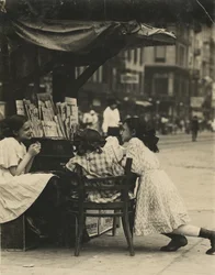 Trois jeunes filles travaillant dans un kiosque à journaux sur Canal Street à New York.