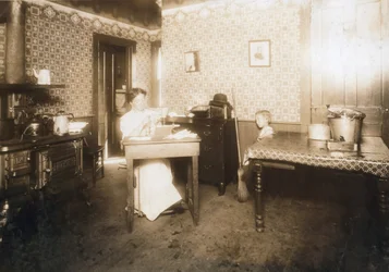 Femme insérant des poils dans des brosses à dents dans sa cuisine, c.1912