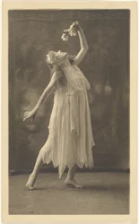 [Danseuse tenant une fleur devant une tapisserie]