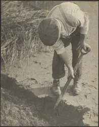 [Homme creusant dans la boue]
