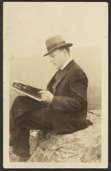 Homme lisant un magazine sur un rocher