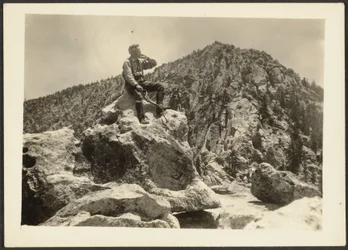 [Homme assis sur des rochers]