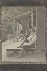 [Hommes assis sous un porche]