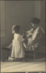 [Mère dans un fauteuil à bascule avec ses enfants]