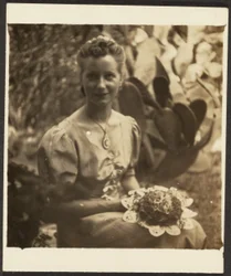 [Femme tenant un bouquet, assise devant un cactus]
