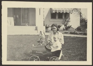 [Femme avec enfants dans une voiture jouet]